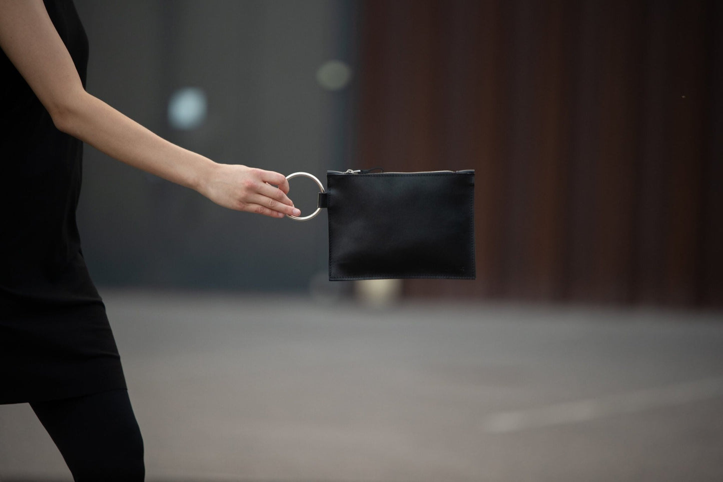 Clutch i svart läder med handtag i form av en metallring från PYKOK - Stadspuls