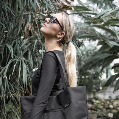 VIK toteväska large i svart kanvas från Nordhale, kvinna bär väskan över axeln